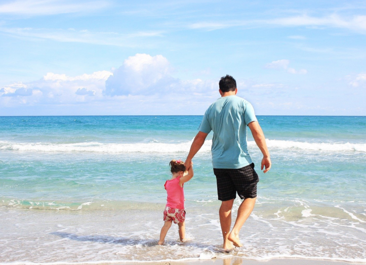 Isä ja tytär hiekkarannalla.